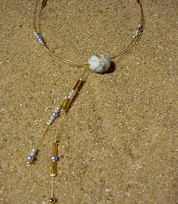 Goldfarbener Edelstahldraht, weiße, hellblaue und goldene Wachsperlen, goldene Glasperlenstifte, eine weiße venizianische Glasperle,, 45 cm.