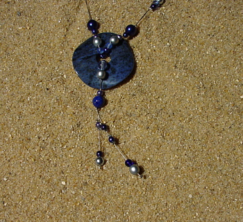 Wachs- und Glasperlen in verschiedenen blautönen und silberfarben, ein 4 cm großer Sodalith-Donut, 44 cm.